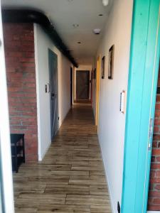 a hallway in a building with a brick wall and wooden floors at Owczarnia Agroturystyka Ekologiczne Gospodarstwo Owczarskie in Dzięgielów