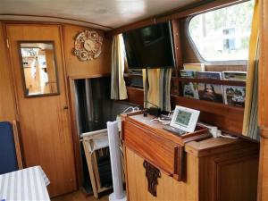 a room with a desk and a television on a boat at Spicy - Séjour insolite sur la Marne in Meaux