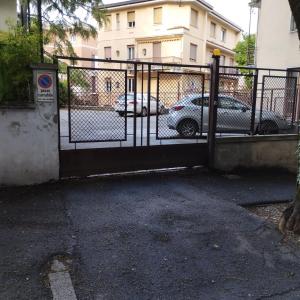 a gate in a parking lot with parked cars at Casa Amadi 2 - La tua casa lontano da casa in Brescia