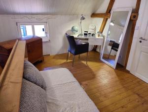 een slaapkamer met een bureau, een bed en een spiegel bij Ferienhaus "Kleinod" in Boizenburg