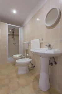 a bathroom with a sink and a toilet and a mirror at Casa Cosmano in Brancaleone Marina