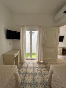 a bedroom with two beds and a sliding glass door at B&B Centro Storico in Diamante