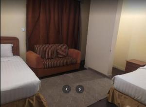 a hotel room with a bed and a chair at Zahret Al Madinah in Al Madinah