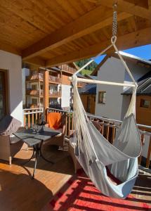 een hangmat op een terras met een tafel en stoelen bij Daniela 3 by SMR Rauris Apartments - inc Spa and National Summercard - near Gondola in Rauris