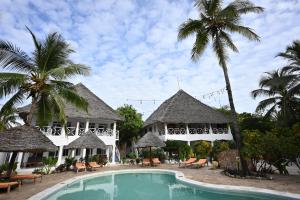 un complejo con piscina y palmeras en Ananda Villa Zanzibar, en Bwejuu