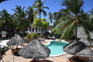 un complejo con piscina, palmeras y sombrillas en Ananda Villa Zanzibar, en Bwejuu