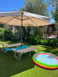 een picknicktafel en een parasol naast een zwembad bij TERRY'S VILLA in Mákri