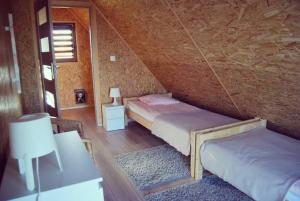 a attic bedroom with two beds and a rug at Cichosza Miłomłyn in Miłomłyn