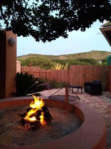 a fire pit in a backyard with a fire pit at Milky Way: Home with large garden, firepit & stars in Kenton on Sea