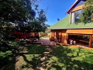 a house with a green roof and a yard at Milky Way: Home with large garden, firepit & stars in Kenton on Sea