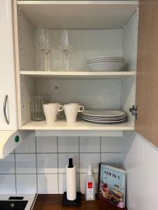 un armario de cocina con platos y vasos en Casa 716 - Minihus nära golf & natur en Bara