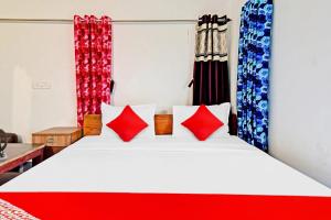 een slaapkamer met een wit bed met rode kussens bij Flagship D.M.2 Resort in Bāgnān