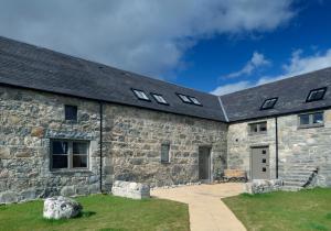 an old stone building with windows on it at Osprey Lodge in Kingussie