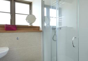 a bathroom with a glass shower and a sink at Osprey Lodge in Kingussie