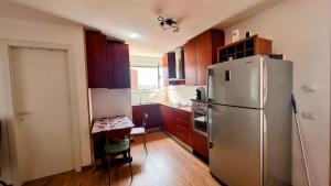 a kitchen with a stainless steel refrigerator and wooden cabinets at Oasi di Serenità in Marino