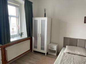 um quarto com uma cama, um armário e uma janela em Rodinný apartmán Mariánská em Varnsdorf