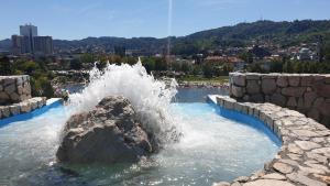 a water fountain in a pool with a rock at Apartmani Sarah Tuzla in Tuzla