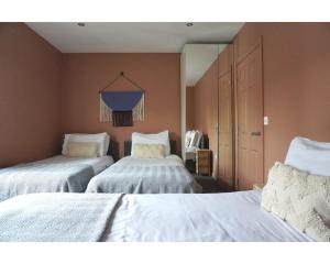 a bedroom with two beds with white sheets and a window at Central Belfast Apartments The Village House in Belfast