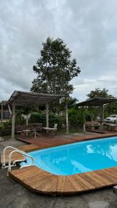 a swimming pool with a wooden deck and a picnic table at Hotel Urumajó in Augusto Correa
