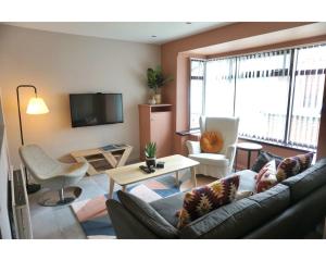 a living room with a couch and a table at Central Belfast Apartments The Village House in Belfast