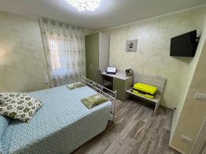 1 dormitorio con 2 camas, escritorio y TV en VittoNico en Morcone