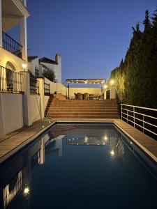 a swimming pool in front of a house at night at Casa Alba in Nerja