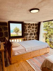 a bedroom with a wooden bed and a window at Greenlife Dağevleri in Rize