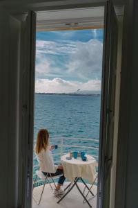 敘拉古的住宿－Panorama Alfeo，坐在船上桌子上的女人
