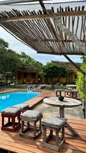 a wooden deck with benches and a swimming pool at Hotel Urumajó in Augusto Correa