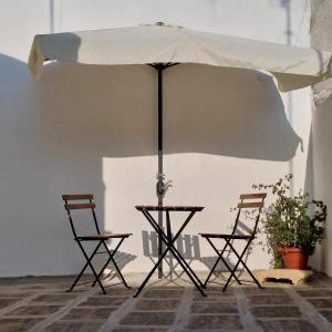 a table and two chairs under an umbrella at la chiocciola in Mesagne