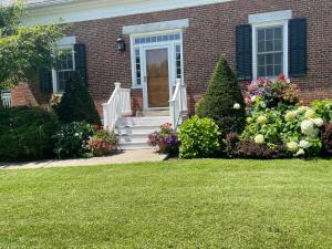 una casa in mattoni con porta bianca e fiori di Dodds Brick House Bed & Breakfast a North Hero