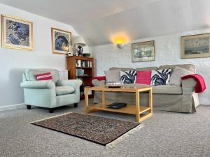 un soggiorno con divano, sedia e tavolo di The Boathouse a Golant