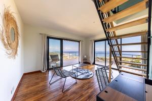 a living room with a spiral staircase and views of the ocean at La Villa Belvédère - Saint Gilles les Bains in Saint-Gilles les Bains
