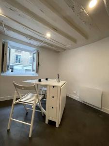 escritorio y silla en una habitación con ventana en Heart of Paris Apartment en París