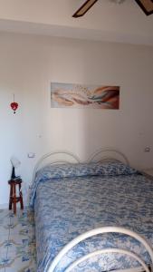 1 dormitorio con 1 cama y una pintura en la pared en B&B Ingrid e Claudia, en Nemoli