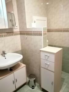 bagno con lavandino bianco e specchio di GingerBED Apartman a Kaposvár