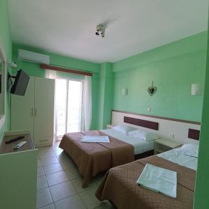 a hotel room with two beds and a window at Casa Angelina in Polychrono
