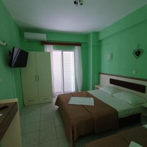 a green bedroom with a bed and a television at Casa Angelina in Polychrono +35 photos