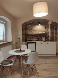 a kitchen with a table and chairs in a room at Apartamenty i pokoje gościnne "Wacuś" in Srebrna Góra