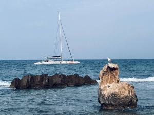 een zeilboot in de oceaan met een rots in het water bij Puerto Romano Denia in Denia