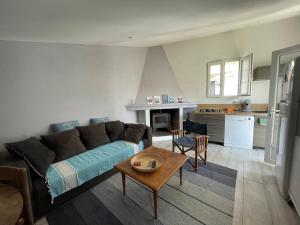 a living room with a couch and a table at La maison de la plage in Saint-Georges-dʼOléron