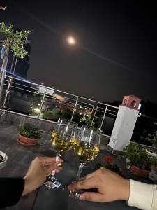 two people holding glasses of wine on a balcony at night at Villa Perla di Mare in Kranevo
