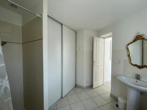 a bathroom with a sink and a toilet and a mirror at La maison de la plage in Saint-Georges-dʼOléron
