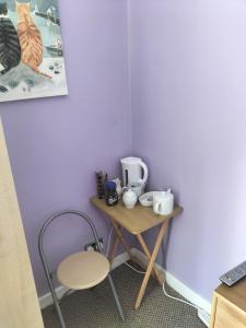 a small table with a chair and cups on it at Private room in Wrexham