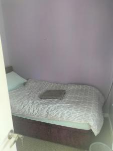 Cama en habitación con pared blanca en Private room en Wrexham