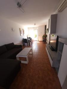 a living room with a couch and a tv at Chalet Edy con piscina in Peñíscola