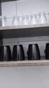 a shelf filled with black bowls and glass jars at C.leslie_homes2 in Bamburi
