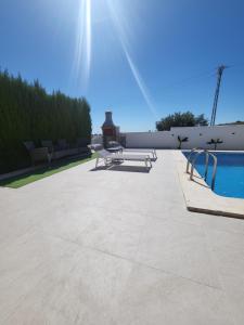 a patio with a picnic table and a swimming pool at Chalet Edy con piscina in Peñíscola