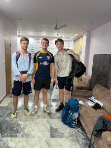 three men posing for a picture in a living room at S B Guest House Near New Delhi Train Station in New Delhi