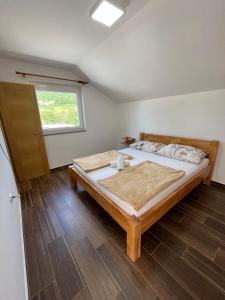 um quarto com uma cama grande e uma janela em Apartmani Dado em Banja Luka